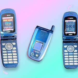 Op de afbeelding: Drie blauwe Sprint klaptelefoons, twee open en één gesloten, tegen een pastelkleurige achtergrond. De open telefoons tonen het Pac-Man spel. De telefoons hebben een Sanyo logo en een Sprint logo. De gesloten telefoon toont "Looking for service".