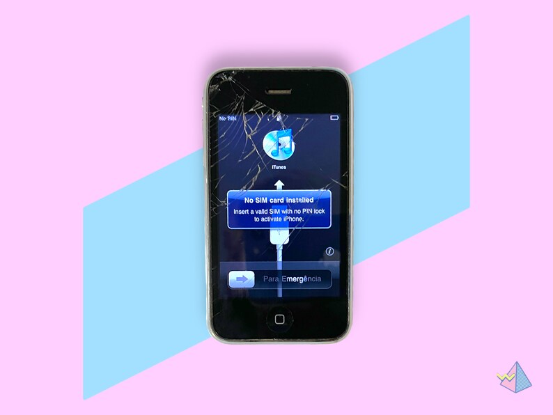 May include: A cracked black iPhone displays a message: "No SIM card installed." The screen shows the iTunes logo and a white charging cable. The phone is set against a pink and blue geometric background.