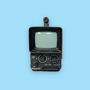 May include: A vintage black Panasonic portable television with a small screen and a built-in antenna. The TV has dials for volume and tuning, and the words "Solid State" and "Panasonic" are visible.