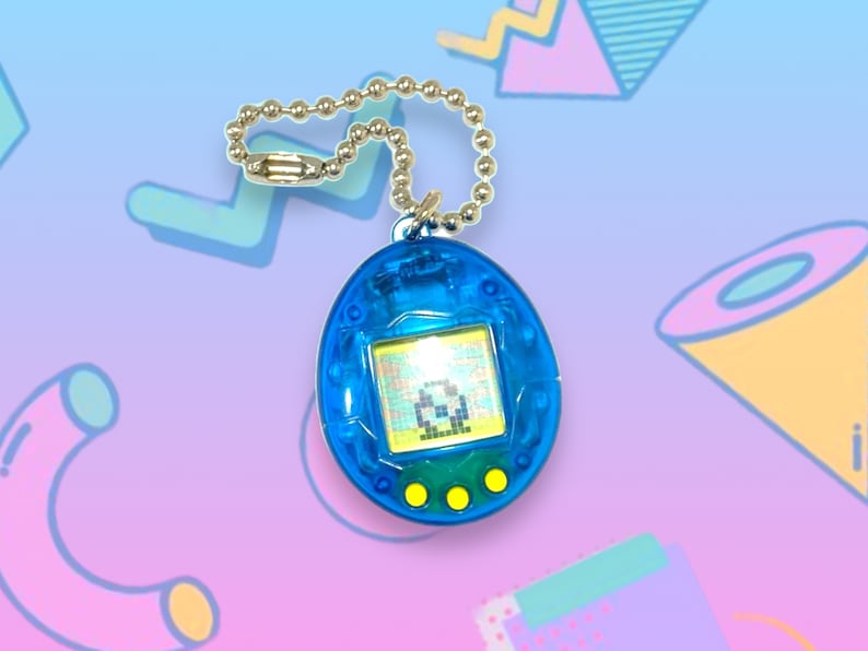 May include: A blue, egg-shaped virtual pet toy with a small screen displaying a pixelated character. The toy has three yellow buttons and a silver chain for attachment. The background features a colorful, geometric design.