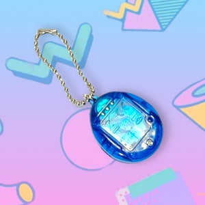 May include: A blue handheld electronic game with a silver chain. The game has a clear, oval-shaped screen with text and graphics. The background is a gradient of blue and pink with geometric shapes.