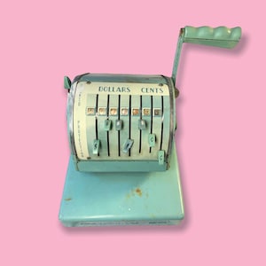 May include: Vintage teal cash register with a handle and dollar and cent indicators. The register has a series of levers and a display that reads "DOLLARS CENTS". The word "PROTECTION" is printed on the side.