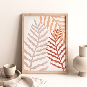 May include: A framed print with a minimalist design featuring two stylized fern leaves in shades of peach, coral, and terracotta on a white background.