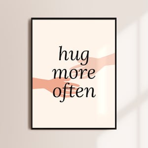 Puede incluir: Un p&oacute;ster de pared imprimible con un dise&ntilde;o minimalista que presenta dos manos que se alcanzan mutuamente con el texto "hug more often" en negro.