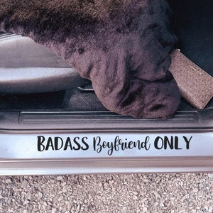 May include: A car door sill with a black vinyl decal that reads "BADASS Boyfriend ONLY".