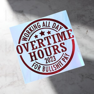 Op de afbeelding: Ronde rode sticker met de tekst "Working All Day Overtime Hours 2023 For Bullshit Pay".