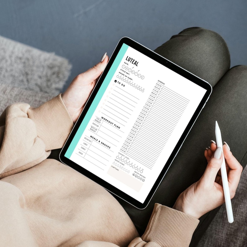 May include: A digital planner on a tablet screen with the title "LUTEAL" and sections for "To Do", "Workout Plan", and "Meals & Snacks".