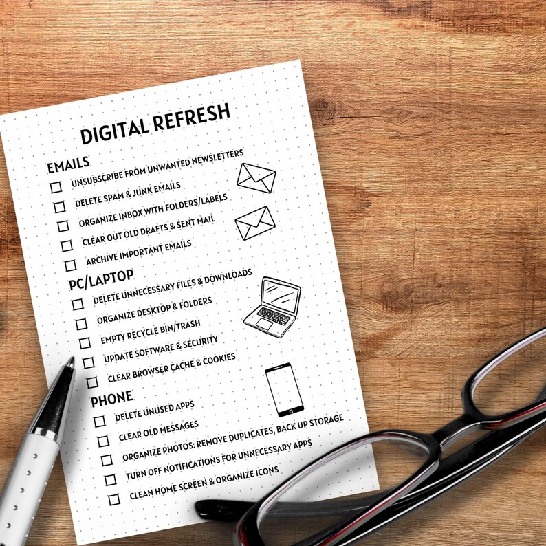 May include: A checklist titled "Digital Refresh" with sections for emails, PC/Laptop, and phone. Each section has a list of tasks to complete, such as unsubscribing from unwanted newsletters, deleting unnecessary files, and clearing old messages. The checklist is printed on white paper with black ink and includes small illustrations of an email, a laptop, and a phone.