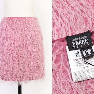 Peut inclure: Mini-jupe rose à franges. La jupe est présentée sur un mannequin. Un gros plan montre la texture de la jupe et une étiquette avec "GIANFRANCO FERRE JEANS" et "MADE IN ITALY".