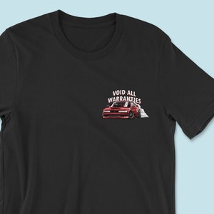May include: Black t-shirt with a red car drifting and the text "VOID ALL WARRANTIES" printed on the front.