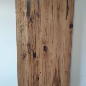 Peut inclure: Un gros plan sur un plateau de table en bois rustique avec un grain de bois naturel et des stries brun foncé. Le bois a un aspect vieilli avec des nœuds et des imperfections.