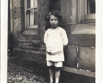 Antique 1910s B&W Photo- Cute Young Boy Wearing Shorts Standing Next To Building 2.9"x4.6" Vernacular Snapshot Photograph