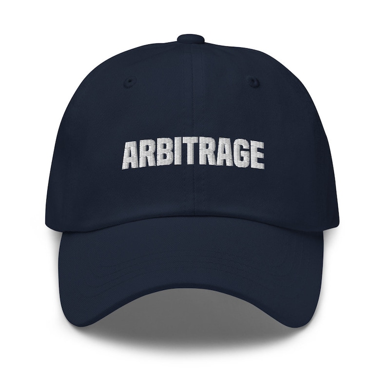May include: A navy blue baseball cap with the word "ARBITRAGE" embroidered in white on the front.
