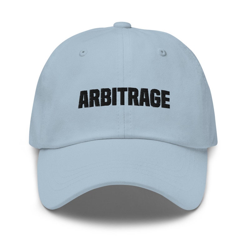 May include: A light blue baseball cap with the word "ARBITRAGE" embroidered in black on the front.