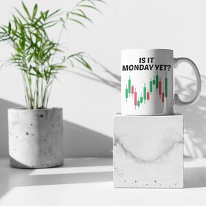 May include: White ceramic mug with a black and green graphic of a stock market chart and the text "Is it Monday yet?"