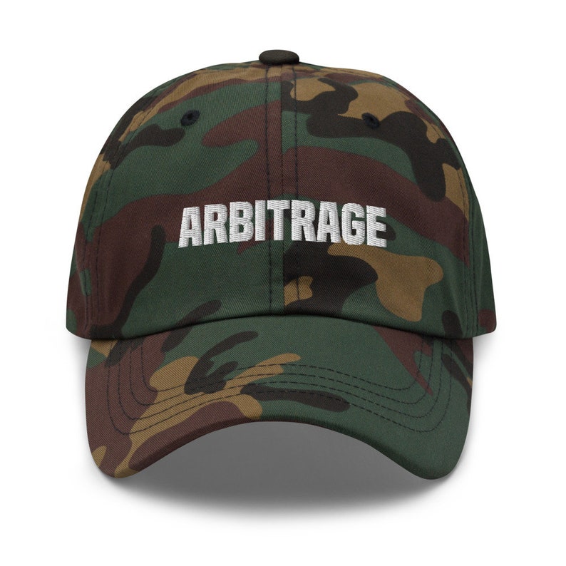 May include: A camouflage baseball cap with the word "ARBITRAGE" embroidered in white on the front.