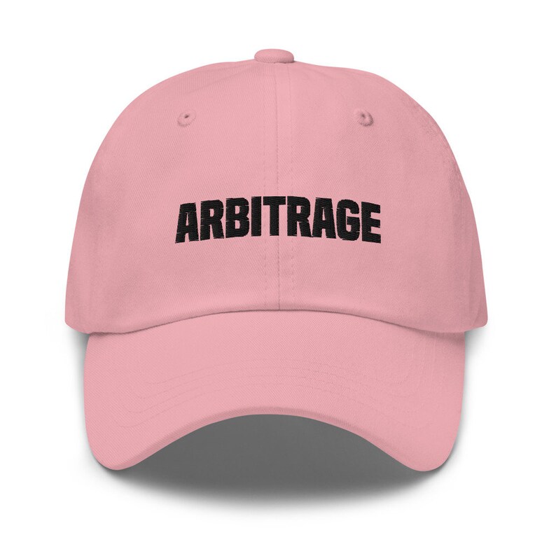 May include: A pink baseball cap with the word "ARBITRAGE" embroidered in black on the front.