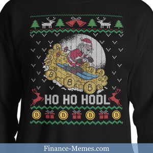 May include: Black sweatshirt featuring a Christmas-themed design. Santa Claus skis on a pile of gold Bitcoin coins in front of a full moon. The words "HO HO HODL" are displayed below the image, with festive accents.
