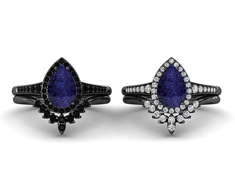 May include: Two black wedding ring sets. Each set features a pear-shaped, blue-speckled stone. One ring is surrounded by black stones, the other by white stones. The bands are black and have additional stones.