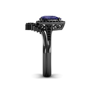 May include: A black ring with a large, rectangular, blue gemstone as the focal point. The ring features a halo of smaller black stones around the main gem and a decorative design on the band. The ring is set against a white background.
