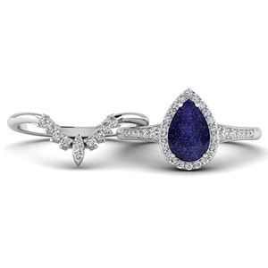 May include: A bridal ring set featuring a pear-shaped blue gemstone ring with a halo of small white stones and a matching curved band. The rings are set in a silver-colored metal, creating a classic and elegant look.