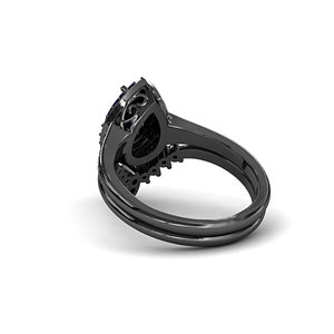 May include: Black engagement ring set with a pear-shaped center stone and a halo of smaller stones. The ring has a black band and a matching band for stacking. The design features intricate details and a dark, elegant aesthetic.
