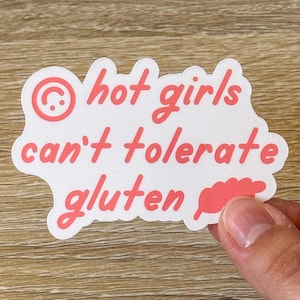 May include: White sticker with pink text that reads "hot girls can't tolerate gluten" with a pink smiley face and a pink wheat stalk graphic.