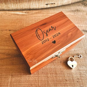 May include: A wooden box with a heart-shaped lock and key. The box is engraved with the name "Oscar" and the dates "2012 - 2024".