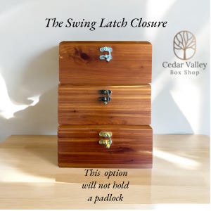 May include: Three wooden boxes stacked on top of each other. Each box has a different type of latch. The top box has a silver latch, the middle box has a black latch, and the bottom box has a gold latch. The boxes are made of cedar wood and have a natural wood finish. The text "The Swing Latch Closure" is at the top of the image. The text "This option will not hold a padlock" is at the bottom of the image. The text "Cedar Valley Box Shop" is in the upper right corner of the image.