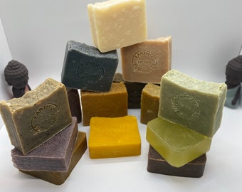 May include: A stack of nine different colored bars of soap with the words "Earth's Substance" and "Est. 2020" on some of the bars.