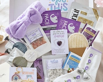 Può includere: Una confezione regalo contenente una fascia in peluche color lavanda, maschere per il viso, sali da bagno, un cristallo a forma di cuore, una spugna luffa, tè Twinings, calzini bianchi con ricami floreali viola e un portachiavi arcobaleno.