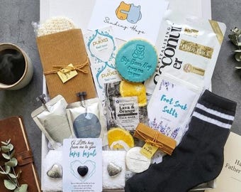 Può includere: Una scatola regalo contenente una pochette in velluto a coste marrone, un biscotto blu a forma di orso con testo, due bustine di tè Pukka, una maschera per piedi al cocco, sali da bagno alla lavanda, una maschera viso all'arancia, un calzino nero e lapislazzuli.