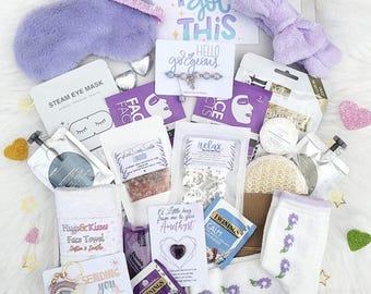 Può includere: Una scatola regalo di auto-cura di colore viola e bianco con una varietà di articoli, tra cui una maschera per gli occhi alla lavanda, bombe da bagno, un asciugamano per il viso, bustine di tè e una fascia per capelli viola. La scatola include anche un biglietto che dice "You got this" e un piccolo cristallo di ametista.
