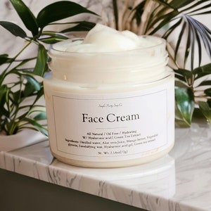 May include: A white jar of face cream with a white label that reads "Face Cream" and lists the ingredients: "All Natural/Oil Free/Hydrating W/Hyaluronic acid | Green Tea Extract Ingredients: Distilled water, Aloe vera juice, Mango butter, Vegetable glycerin, Emulsifying wax, Hyaluronic acid gel, Green tea extract Net. Wt. 2.54oz(72g)"