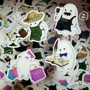 Könnte beinhalten: Eine Sammlung weißer Geisteraufkleber mit verschiedenen Designs. Ein Aufkleber zeigt einen Geist mit Strohhut und Latzhose, der eine Pflanze gießt. Ein anderer hat einen Geist mit Schnurrbart und einer Schürze mit der Aufschrift "D(E)AD".