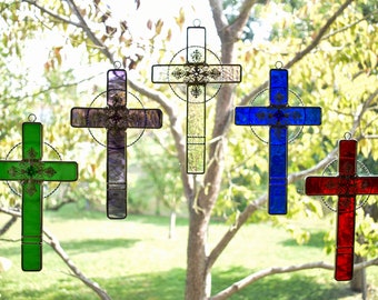 May include: Five stained glass crosses in different colors, including green, purple, white, blue, and red. Each cross has a decorative design in the center.