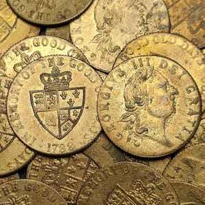 May include: A collection of antique gold coins. One coin features a crowned shield with the inscription "IN MEMORY OF THE GOOD OLD DAYS 1789". Another coin displays a profile and the inscription "GEORGIVS III DEI GRATIA".