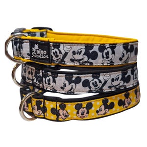 Könnte beinhalten: Drei Hundehalsbänder mit gelbem Hintergrund und schwarz-weißem Mickey-Maus-Druck. Das obere Halsband hat einen schwarz-gelben Hintergrund, das mittlere Halsband einen weißen Hintergrund und das untere Halsband einen gelben Hintergrund mit weißen Punkten. Die Halsbänder sind alle mit schwarzem Stoff gefüttert. Das obere Halsband hat ein Etikett mit der Aufschrift "Dino Fashion".