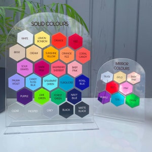 K&ouml;nnte beinhalten: Zwei transparente Acryl-Farbkarten mit einer Vielzahl von Voll- und Spiegelfarben. Die gr&ouml;&szlig;ere Karte zeigt ein Raster sechseckiger Farbmuster mit Namen wie "Rot", "Blau" und "Orange". Die kleinere Karte zeigt Spiegelfarben.