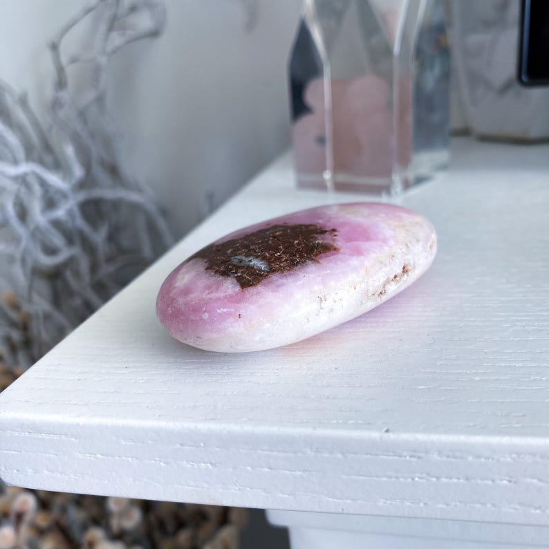 Pink stone with a dark center on a white surface