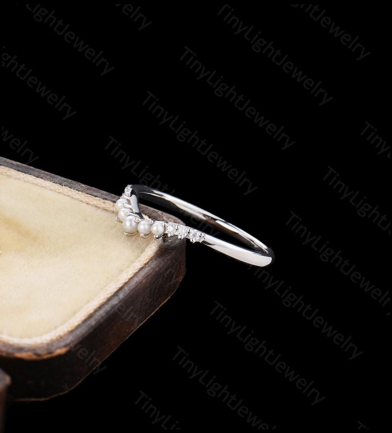 a close up of a wedding ring with pearls