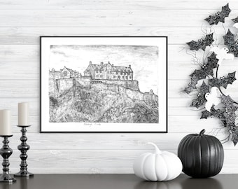 Puede incluir: Una impresión en blanco y negro enmarcada del Castillo de Edimburgo, exhibida en una pared de madera blanca. La impresión está acompañada de candelabros negros, calabazas blancas y negras y una decoración de Halloween con murciélagos y fantasmas.