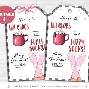 Pode incluir: Etiqueta de presente imprim&iacute;vel com fundo xadrez preto e branco. A etiqueta apresenta uma caneca rosa com chocolate quente e marshmallows, um par de meias rosa e felpudas, e o texto "Here's to hot chocs and fuzzy socks! Merry Christmas! From:"