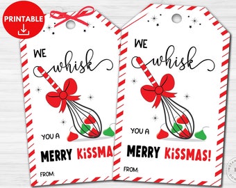 May include: Two rectangular gift tags with red and white striped borders. The tags feature a black whisk illustration with a red bow, containing red and green chocolate drops. Text reads: WE whisk YOU A MERRY KISSMAS! FROM: with small stars.