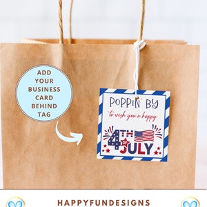 May include: A brown paper bag with a blue and white striped tag that says "Poppin' By to wish you a happy 4th of July". The tag has a red, white, and blue American flag and fireworks. A circle on the bag says "Add your business card behind tag".