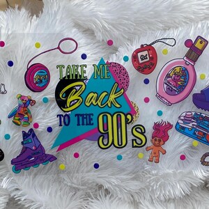 Peut inclure: Ensemble d'autocollants sur le th&egrave;me des ann&eacute;es 90, comprenant un Polly Pocket, un yo-yo, un Tamagotchi, un flacon de parfum, une sandale &agrave; plateforme, un patin &agrave; roulettes, une poup&eacute;e troll et des POGs. Le texte "Take Me Back to the 90's" est &eacute;galement inclus.