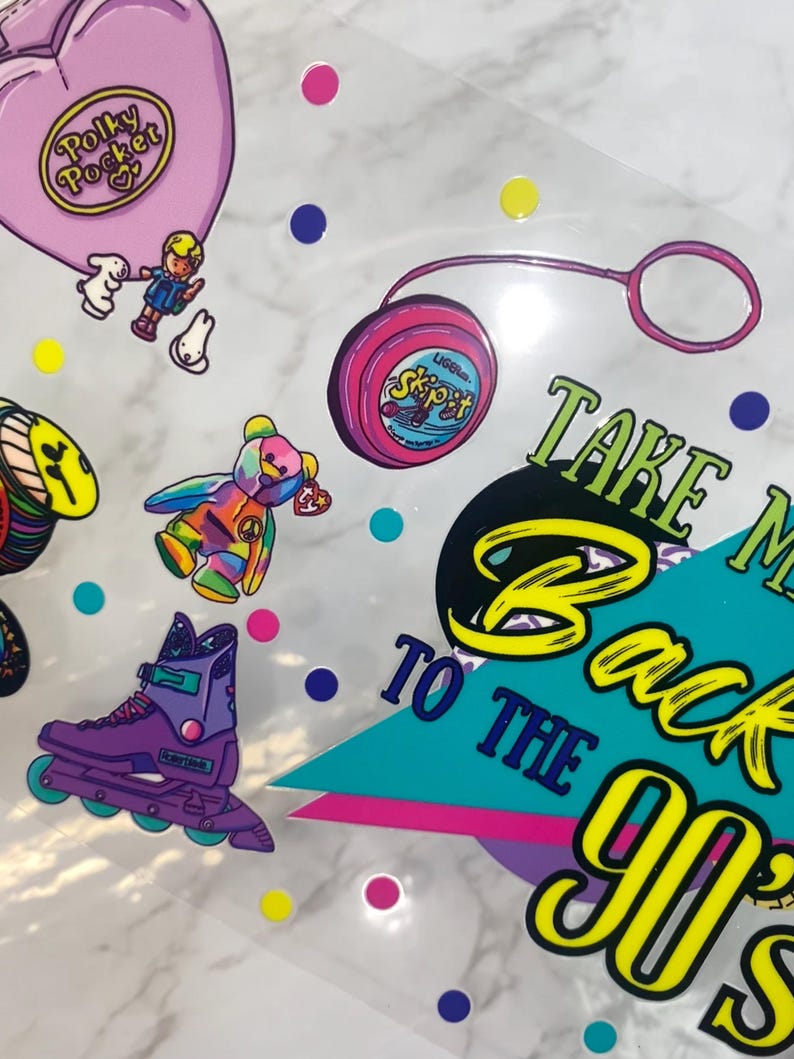 Peut inclure: Ensemble d'autocollants sur le th&egrave;me des ann&eacute;es 90, avec un Polly Pocket rose, un yo-yo, un ours Beanie Baby color&eacute; et des rollers violets. La phrase &laquo;&nbsp;Take Me Back To The 90s&nbsp;&raquo; est &eacute;galement pr&eacute;sente.