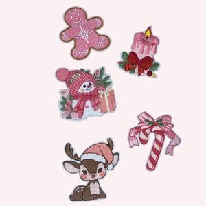 Puede incluir: Un conjunto de parches navideños bordados. Los parches incluyen un hombre de jengibre rosa, un muñeco de nieve con un regalo, una vela con un lazo, un reno con un gorro de Papá Noel y un bastón de caramelo con un lazo.