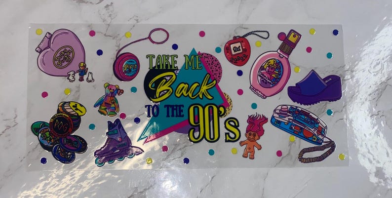 Peut inclure: Une planche d'autocollants sur le th&egrave;me des ann&eacute;es 90, avec un yo-yo, des patins &agrave; roulettes, une poup&eacute;e troll et le texte "Take Me Back to the 90's". Le design comprend divers points color&eacute;s et d'autres objets nostalgiques.