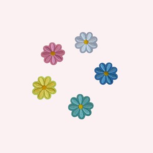 May include: Five colorful daisy flower patches in pink, light blue, blue, green, and teal. Each flower has a yellow center and a stitched edge. These embroidered appliques are ideal for adding a decorative touch to clothing or accessories.